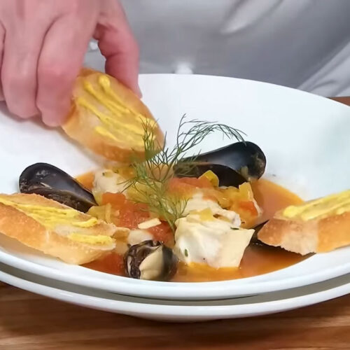 Serving Bouillabaisse French Fish Soup with Crostini